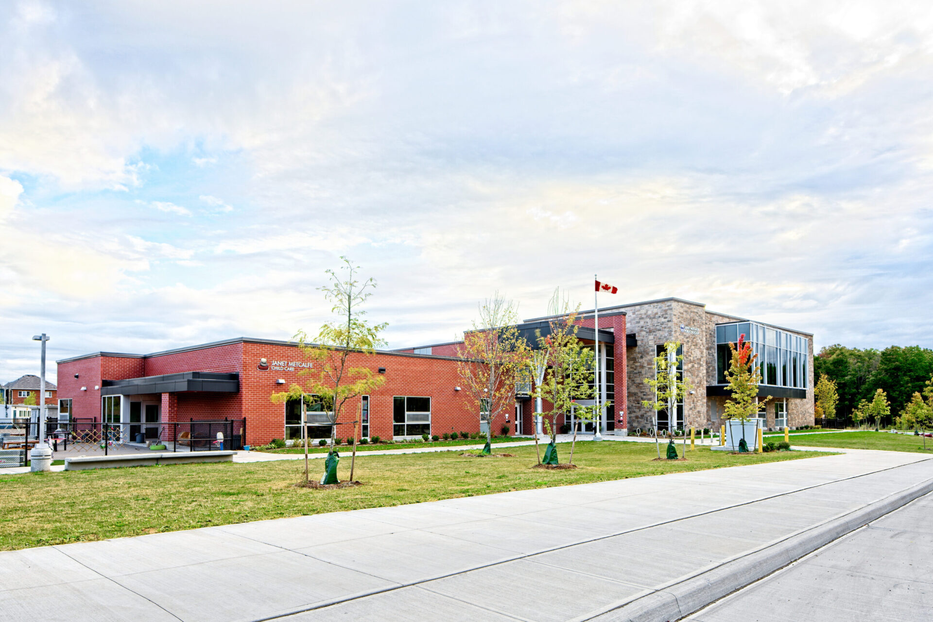 The front of a building showcasing its architecture surrounded by grass and trees.